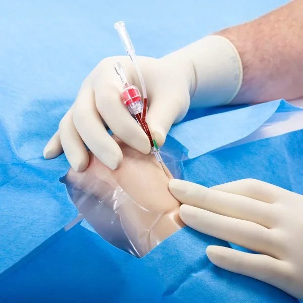 a hand in medical gloves holding a Arteriosel arterial cannula to extract blood from a wrist